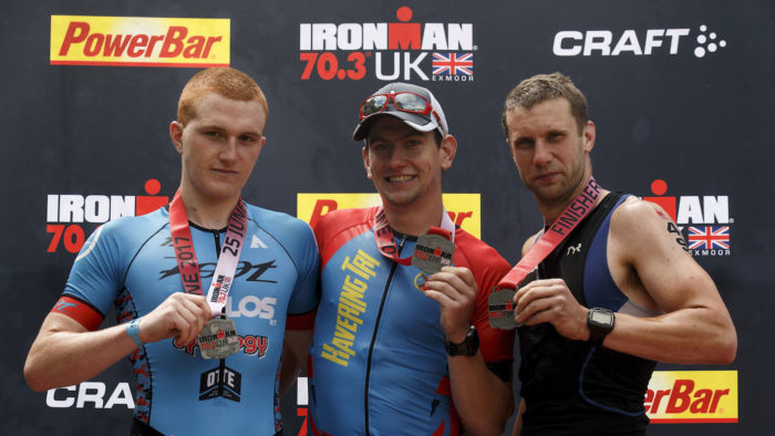 SOMERSET, UNITED KINGDOM - JUNE 25: Secon place athlete Max Hazell (L), first place athlete Marton Cseik and third pace athlete Oliver Burrows (R), all of them from Great Britain pose for a picture at the top three podium during the Ironman 70.3 UK Exmoor at Wimbleball Lake on June 25, 2017 in Somerset, United Kingdom. (Photo by Gonzalo Arroyo Moreno/Getty Images for Ironman)