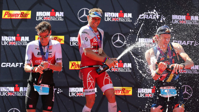 BOLTON, ENGLAND - JULY 16: Cyril Viennot of France (C) celebrates winning Ironman UK with Will Clarke of Britain (L) second and Kotsegarov Kirill of Estonia (R) third on July 16, 2017 in Bolton, England. (Photo by Nigel Roddis/Getty Images for Ironman)