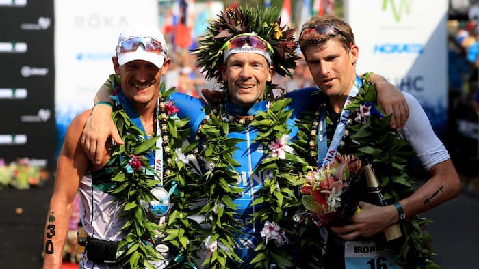 KAILUA KONA, HI - OCTOBER 14: (C) Patrick Lange of Germany celebrates after winning the IRONMAN World Championship along with (L) Lionel Sanders of Canada who finished second and David McNamee of Great Britain who finished on October 14, 2017 Third in Kailua was Kona, Hawaii.  (Photo by Sean M. Haffey/Getty Images for IRONMAN)