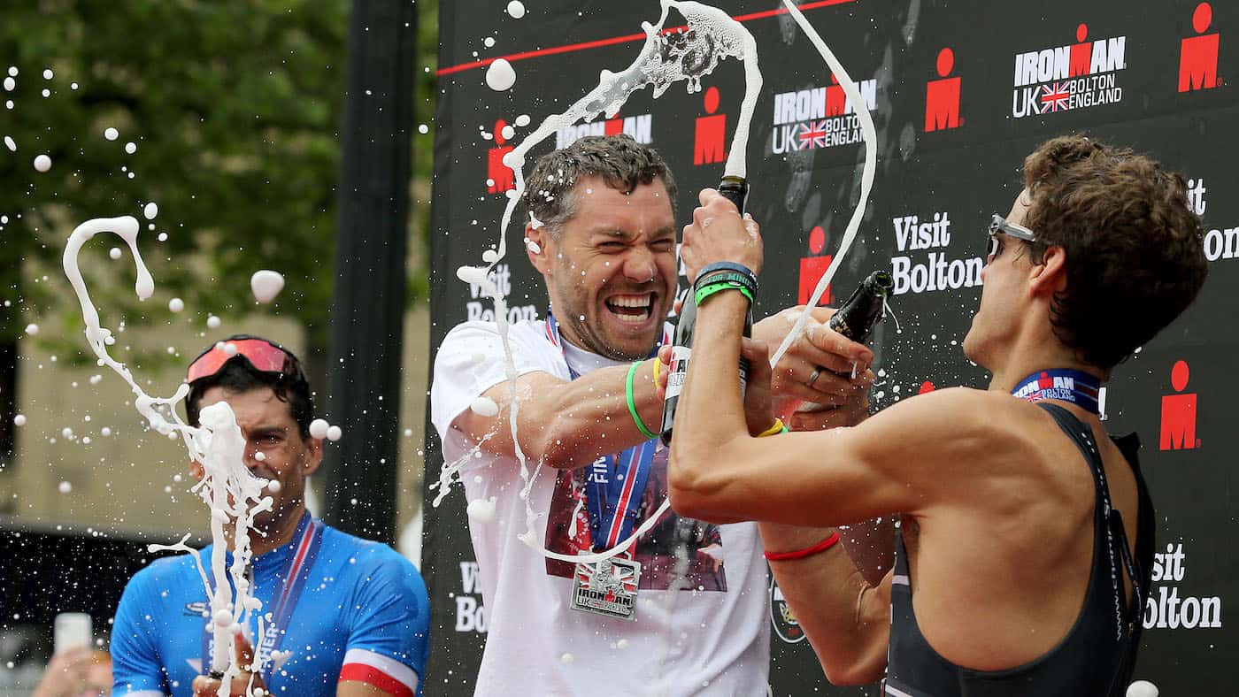 BOLTON, ENGLAND - JULY 14: Brian Fogarty of Britain (C) reacts on the podium after winning Ironman UK on July 14, 2019 in Bolton, United Kingdom. (Photo by Nigel Roddis/Getty Images for IRONMAN)