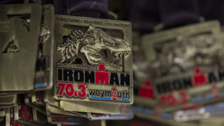 WEYMOUTH, ENGLAND - SEPTEMBER 22: Finisher medals hung from hook at the finish line of Ironman Weymouth 70.3 on September 22, 2019 in Weymouth, England. (Photo by Pablo Blazquez Dominguez/Getty Images for IRONMAN)