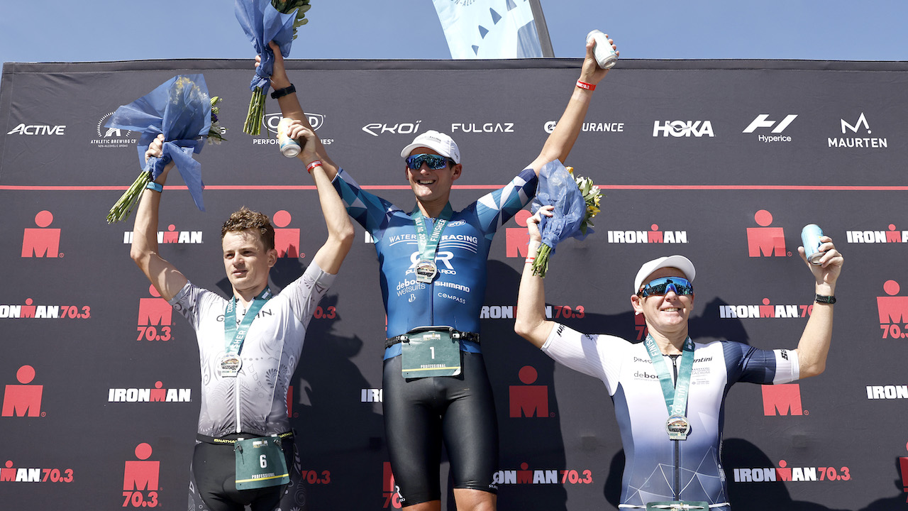 SALEM, OREGON - JULY 10: Justin Metzler, center, Jack Moody, left, and Kyle Buckingham celebrate on the podium after finishing IRONMAN 70.3 Oregon on July 10, 2022 in Salem, Oregon. (Photo by Michael Owens/Getty Images for IRONMAN)