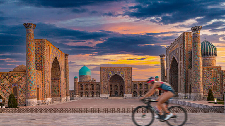 Cyclist passes stunning architecture at Challenge Samarkand