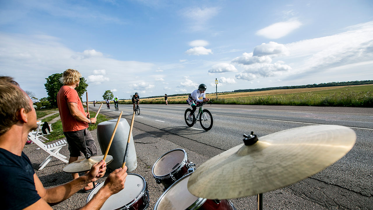 IRONMAN Kalmar - band on bike course IRONMAN Kalmar - cyclist riding by a band on the bike course
