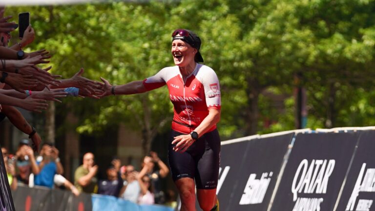 Kat Matthews high fives IRONMAN Texas finish line 2023