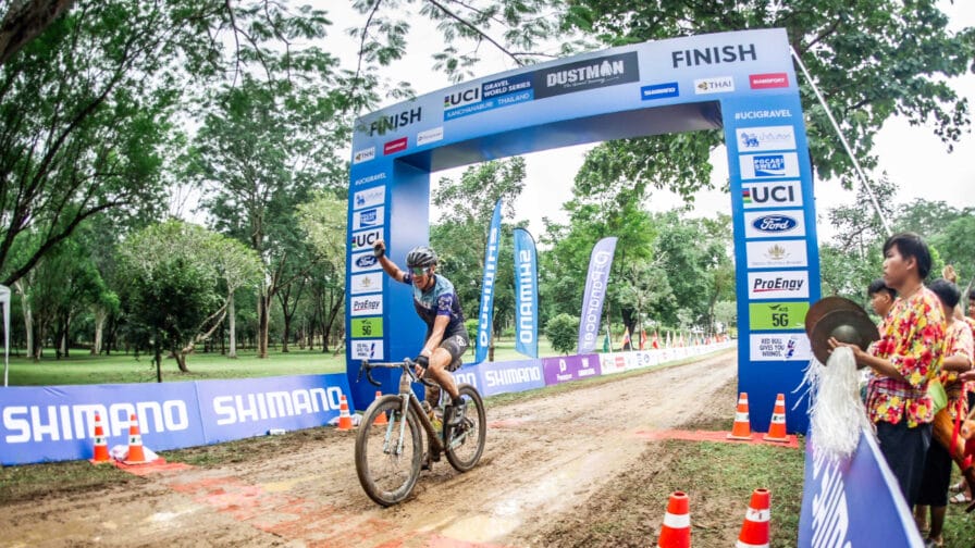 Caroline Livesey celebrates as she crosses the line to win the first UCI gravel race to be held in Thailand. [Photo credit: UCI] 
