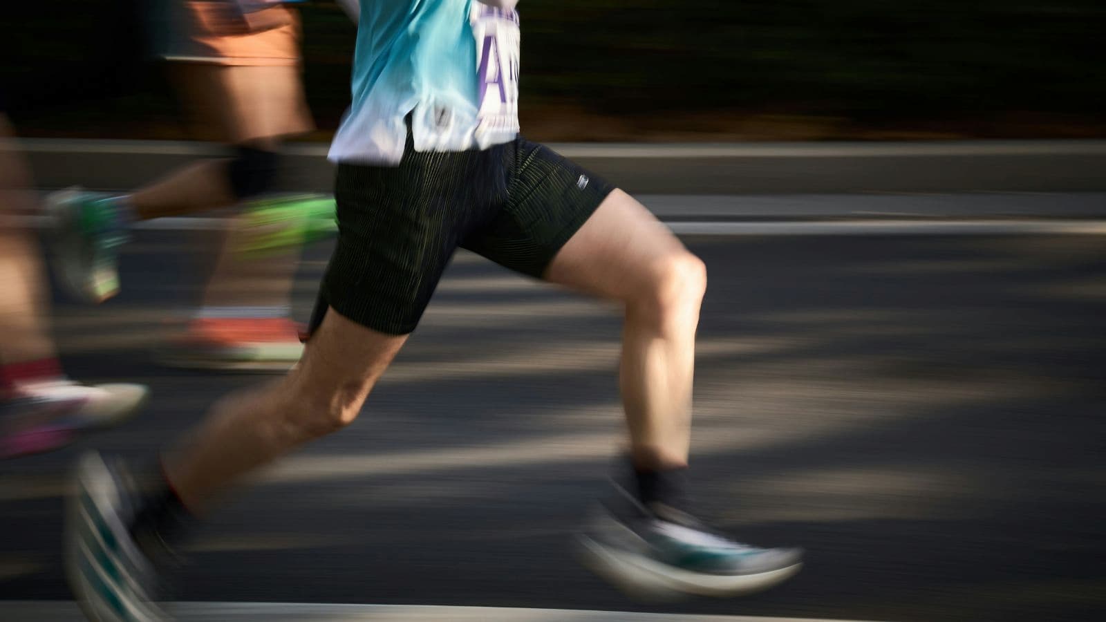 Runner’s lower body in motion during triathlon run, showing strong stride and efficient running form