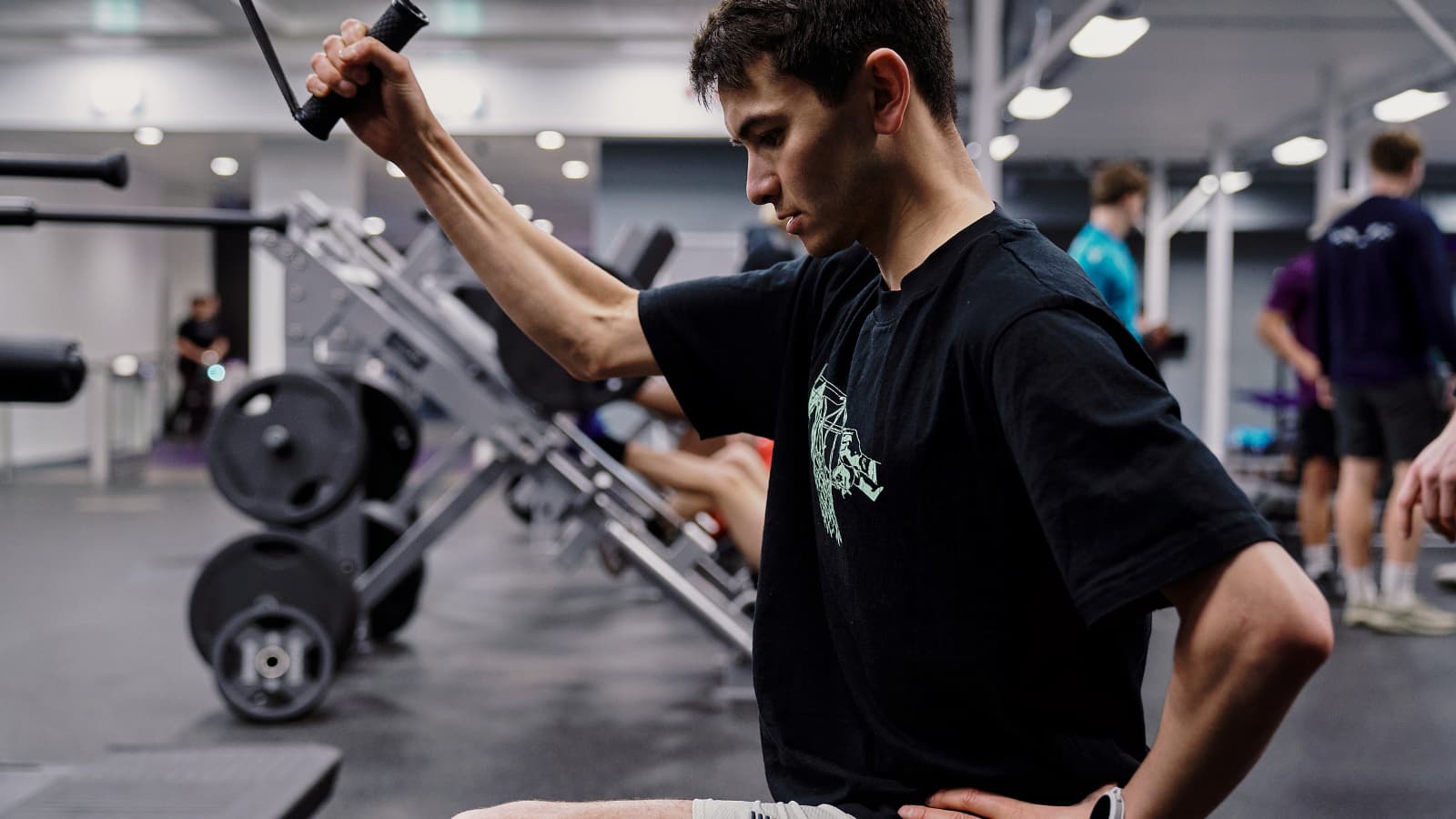 Alex Yee performing strength training exercises in a gym to enhance triathlon performance, focusing on power, stability, and endurance across swim, bike, and run.