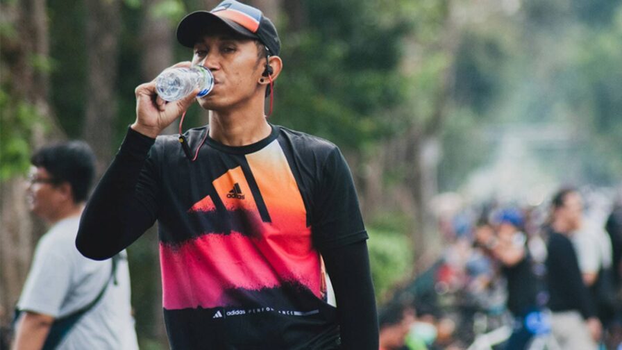 Endurance triathlete consuming electrolytes mid-race to prevent dehydration and fatigue