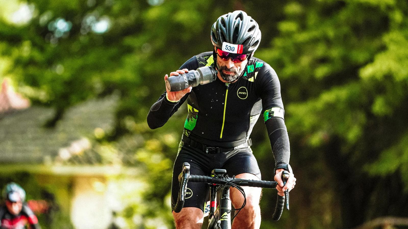 triathlete consuming energy gel and hydration during bike leg of triathlon to maintain endurance