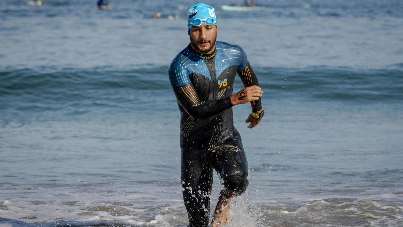 triathlete in full sleeve wetsuit swimming in open water for triathlon training and racing
