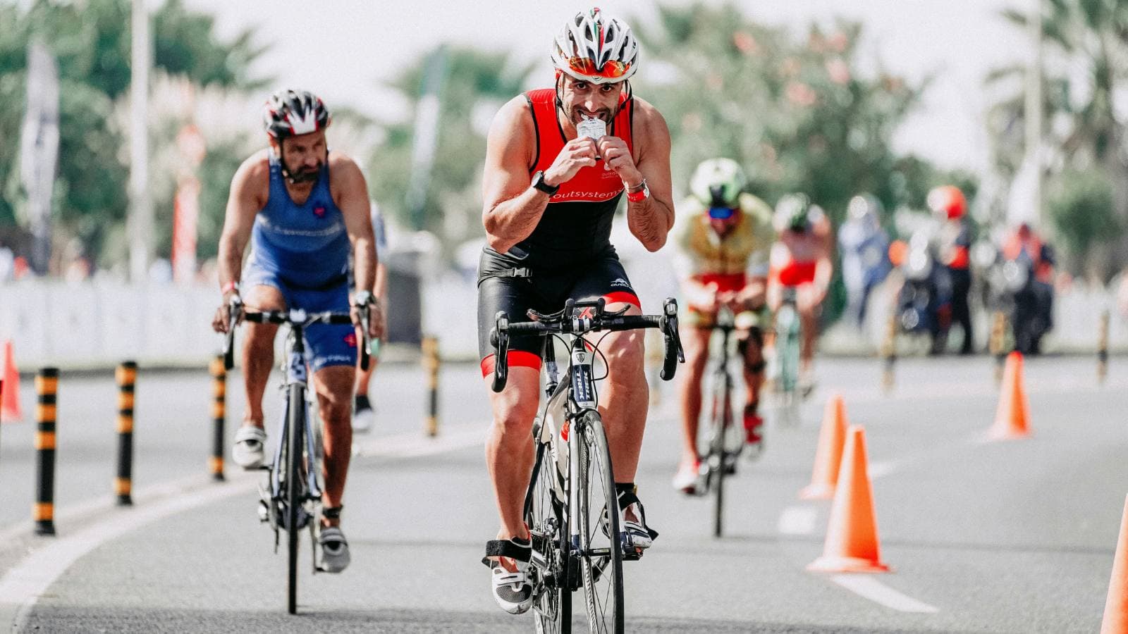 Triathlete drinking sports nutrition during race to maintain energy after carb loading for endurance performance