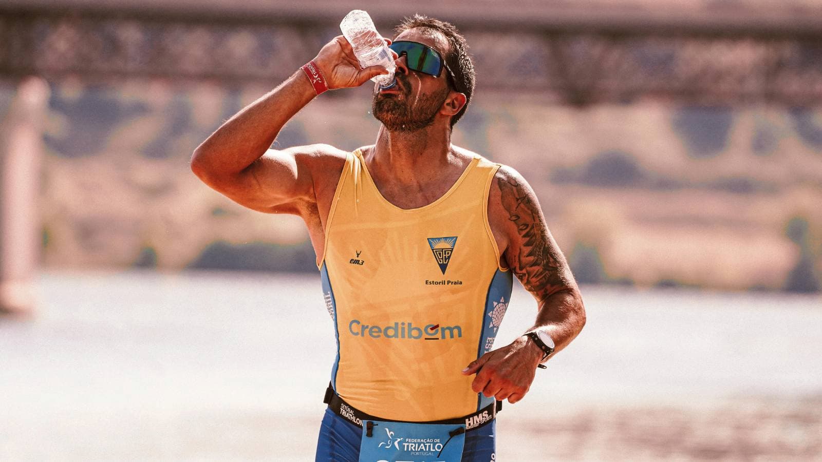 Triathlete drinking electrolyte solution during long distance training to maintain hydration and performance