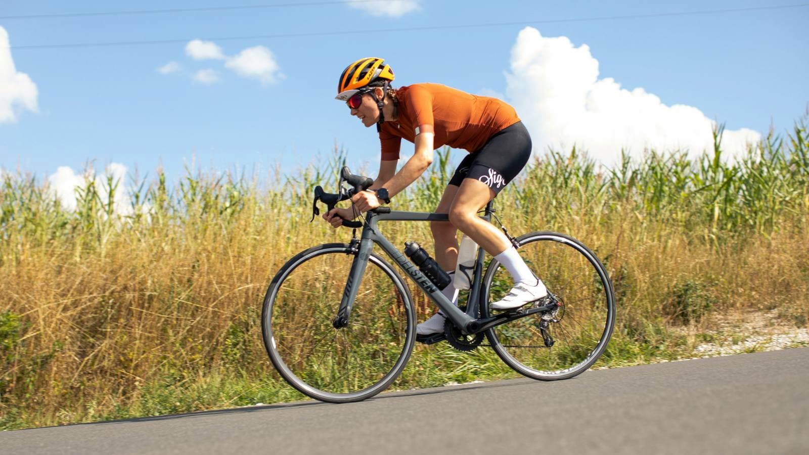 Triathlete training outdoors in aero position aiming to improve FTP and cycling endurance on open road