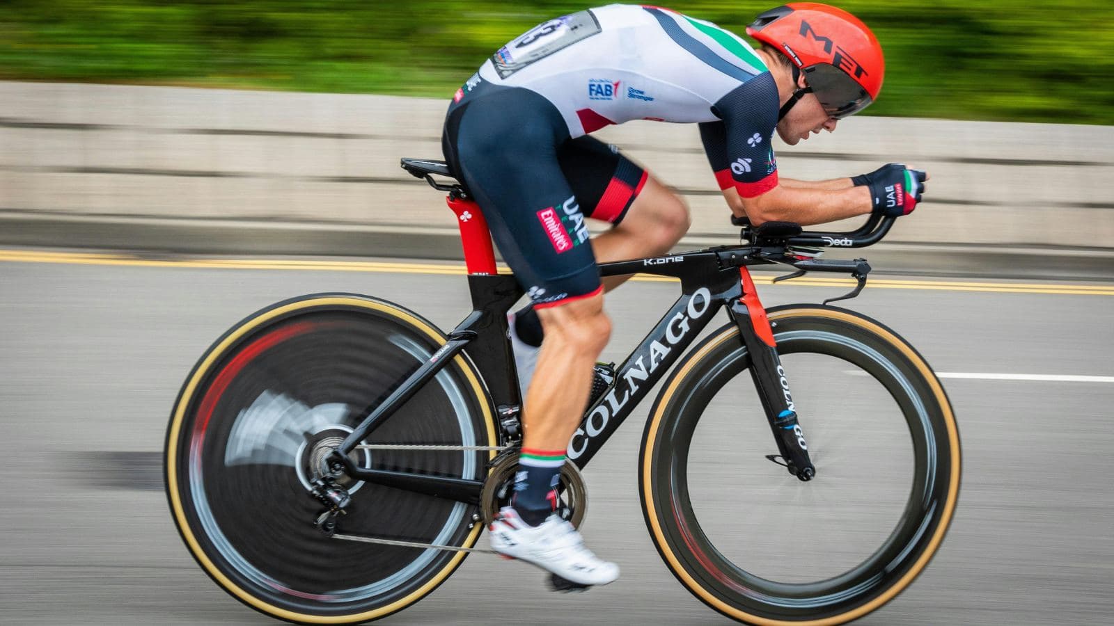 triathlete using aerodynamic body position while descending steep hill during bike leg