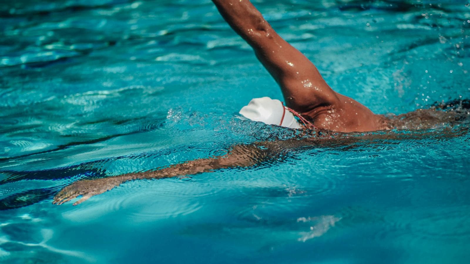 swimmer practicing technique drills in pool while maintaining motivation and avoiding training burnout