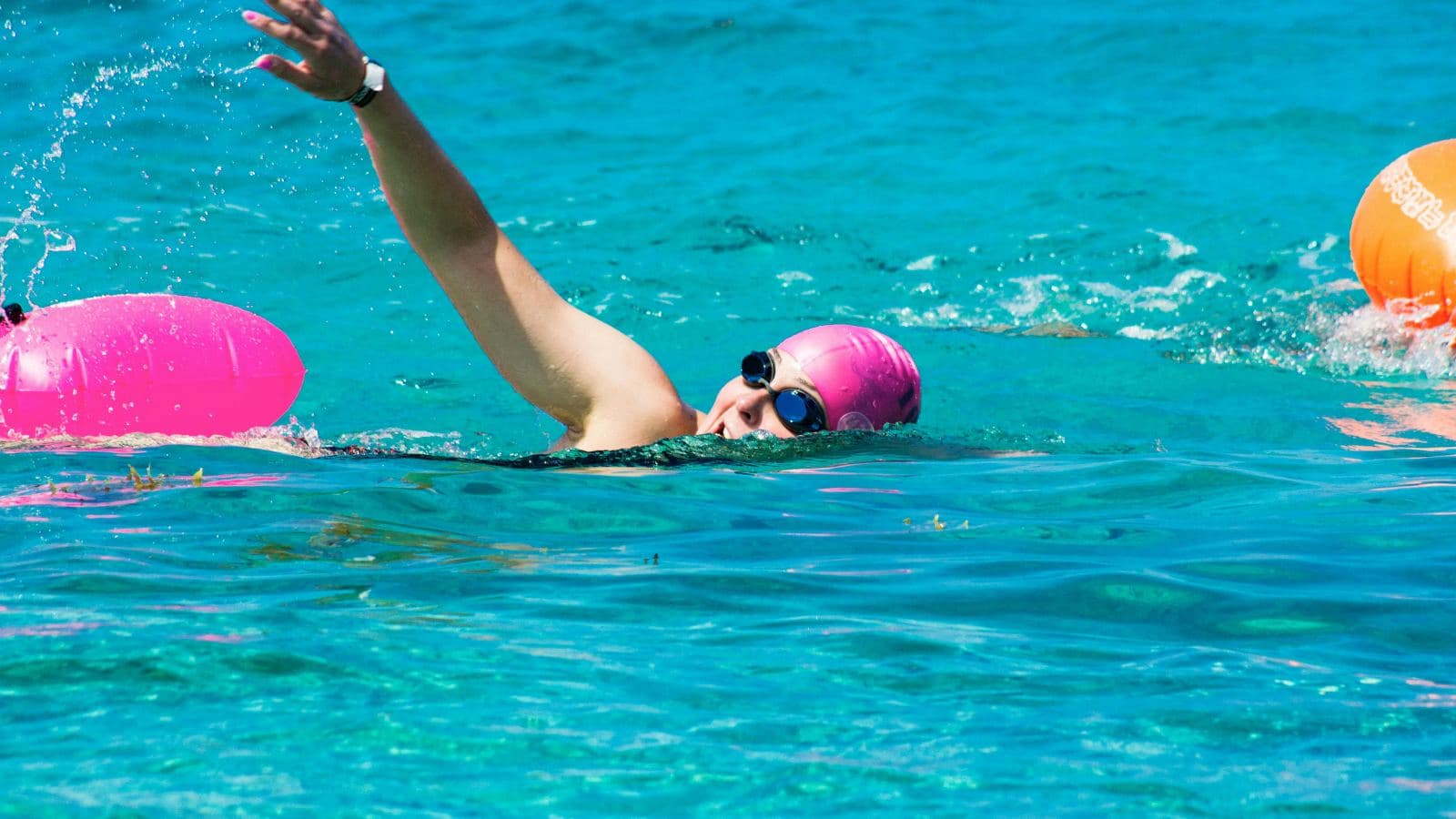 swimmer using hand paddles during pool workout to improve swim strength and technique