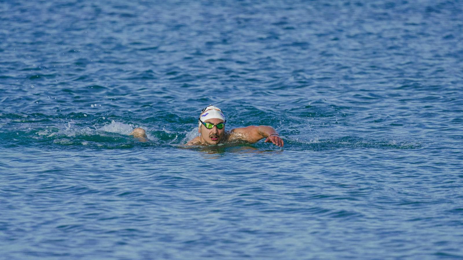 triathlete swimming freestyle in open water with efficient technique and streamlined body position