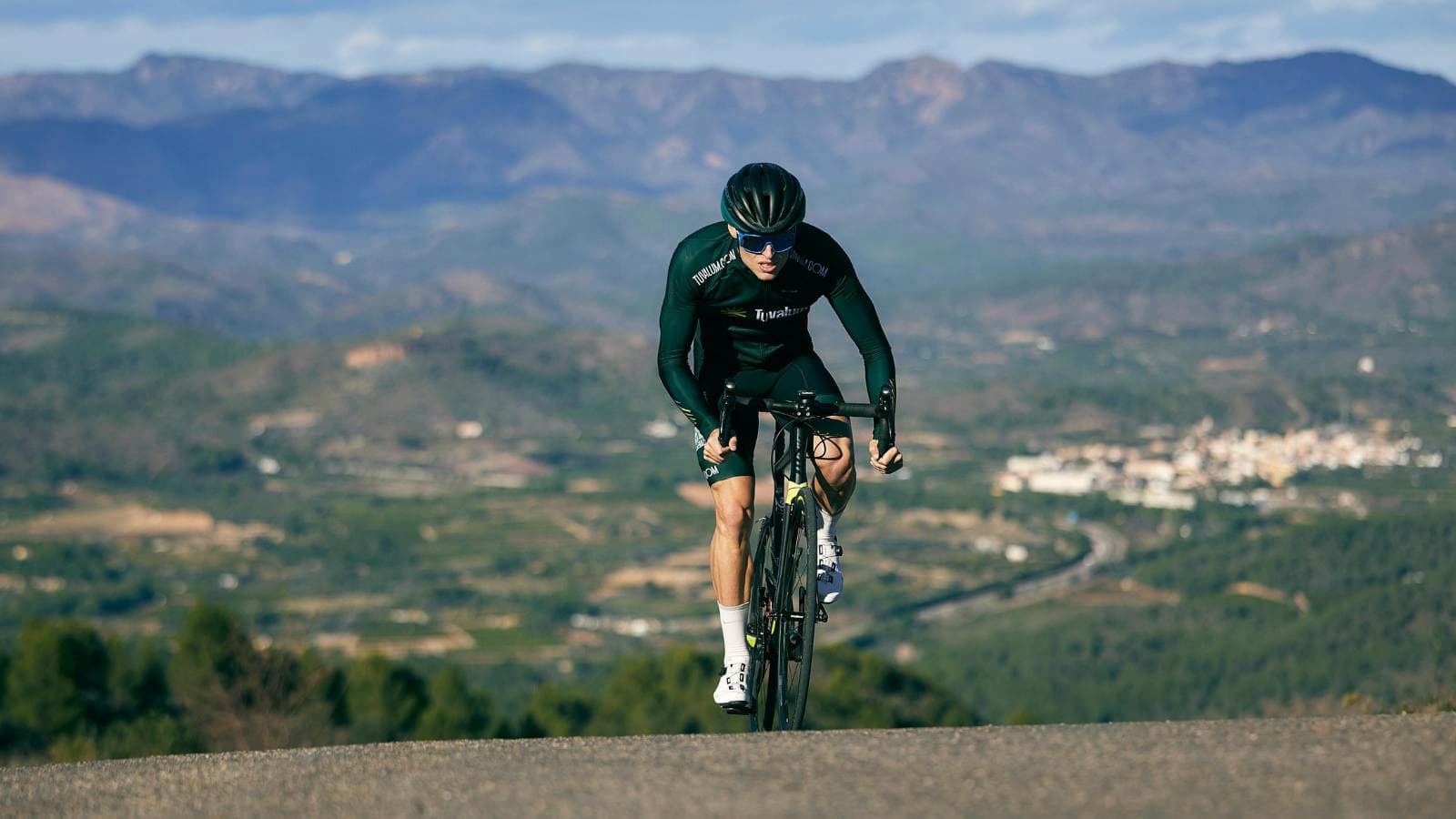 triathlete using proper cadence and gearing while climbing hill during cycling segment