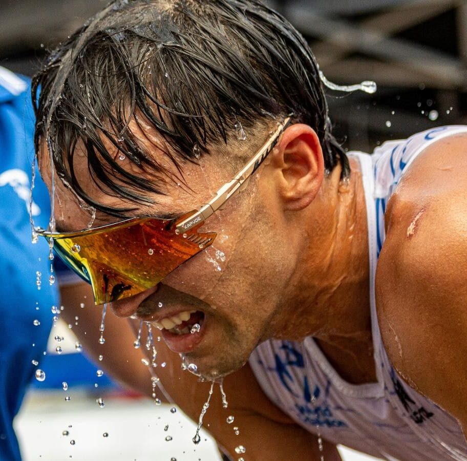 triathlete using sports drink and water after race to prevent rehydration mistakes