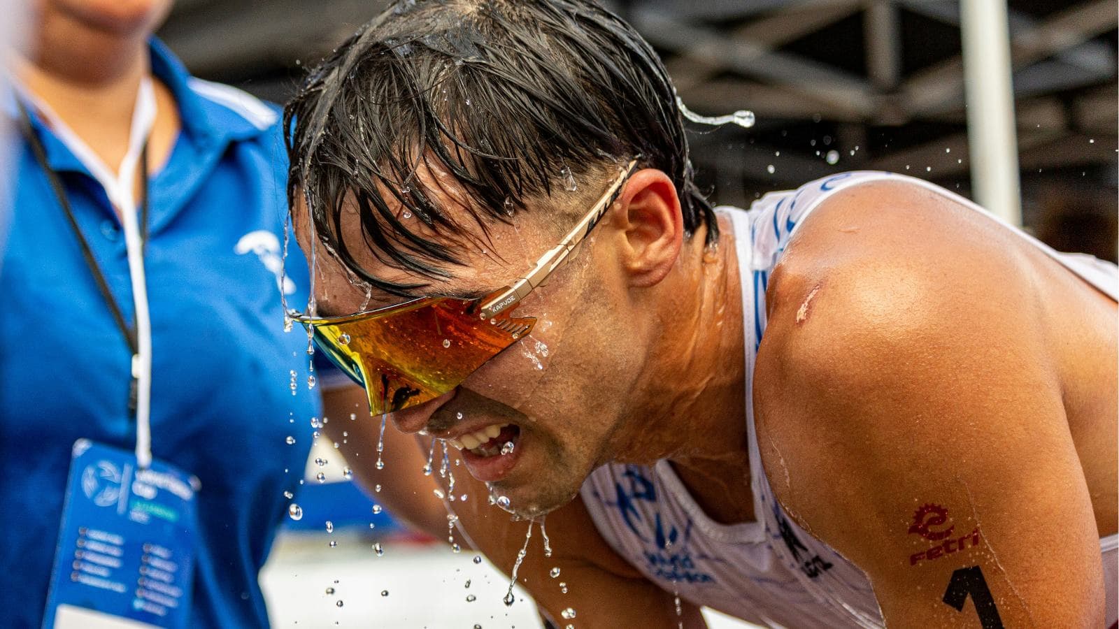 triathlete using sports drink and water after race to prevent rehydration mistakes