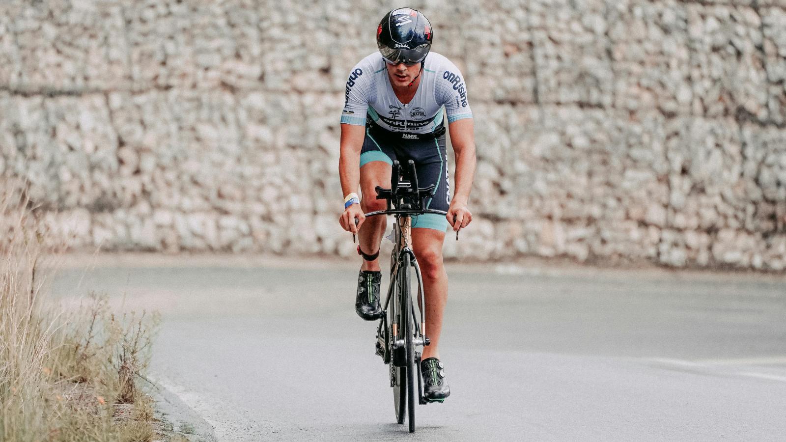 cyclist stretching upper back and shoulders to relieve stiffness caused by long rides in aero position