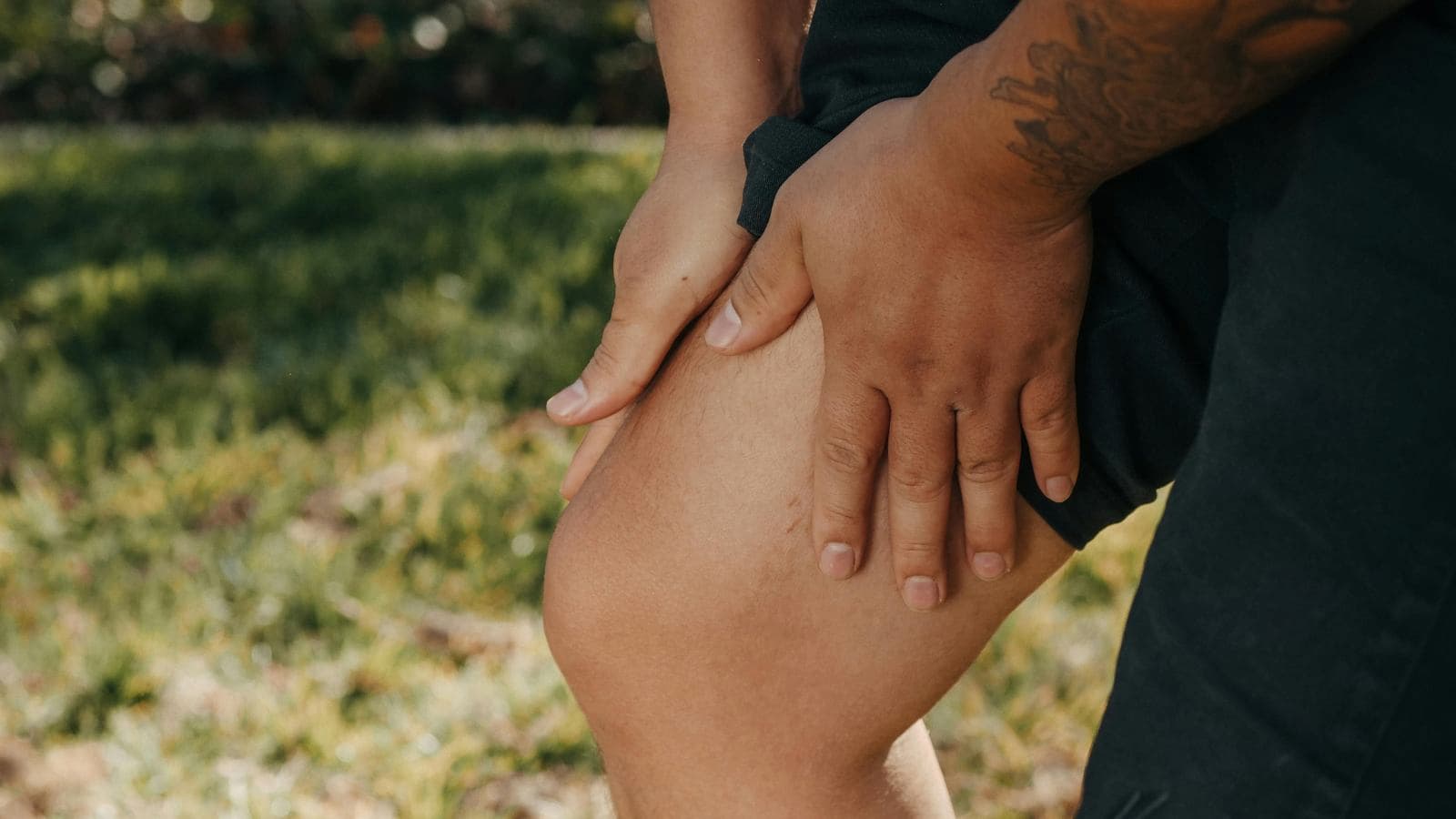 triathlete experiencing knee pain during run portion of triathlon race after cycling