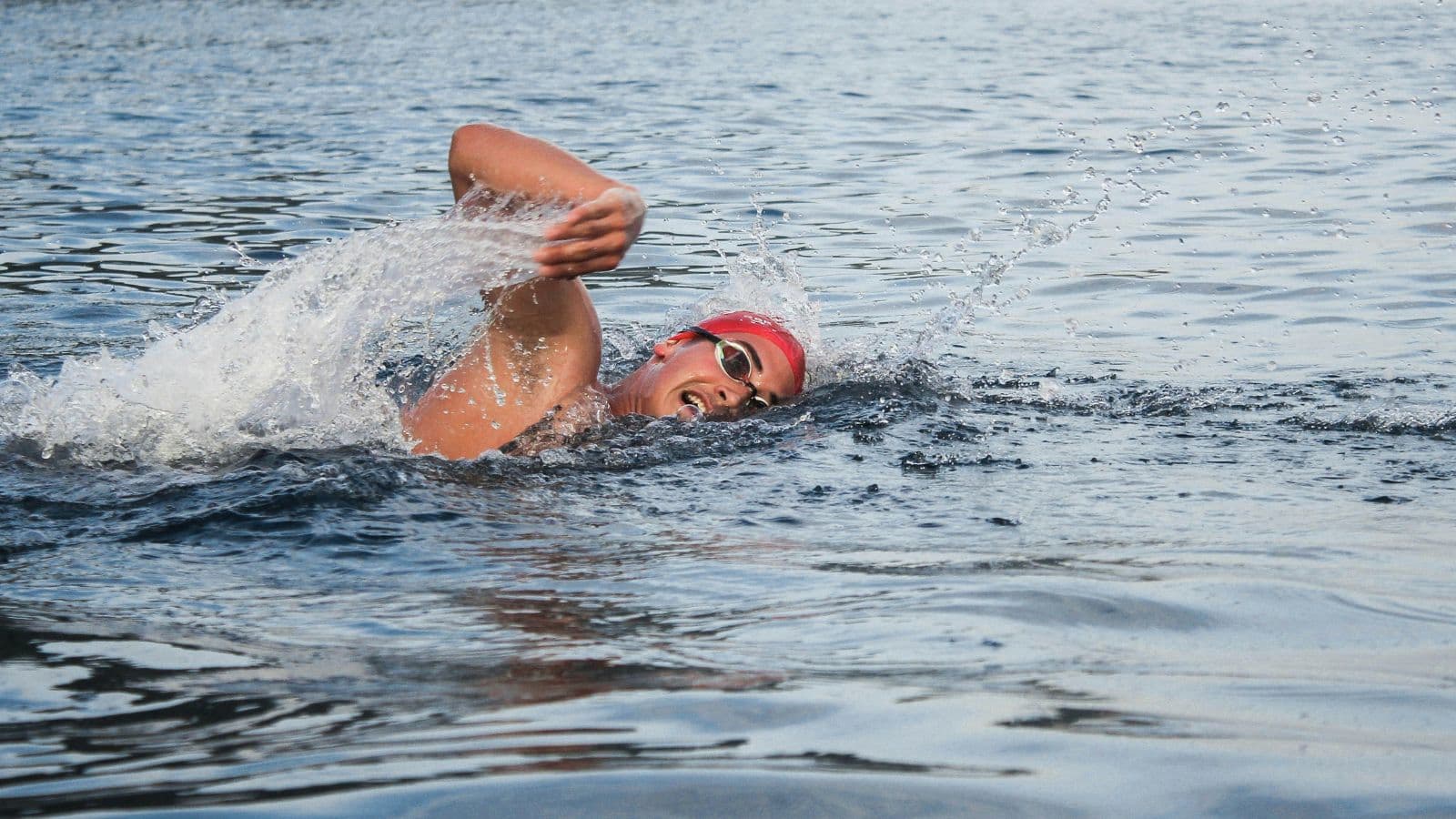 triathlete swimming in open water while adapting to waves currents and changing race conditions