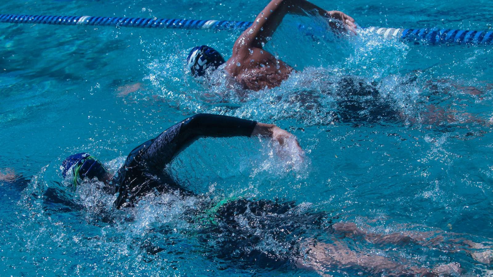 triathlete experiencing shoulder discomfort during swim training due to swimmer’s shoulder injury
