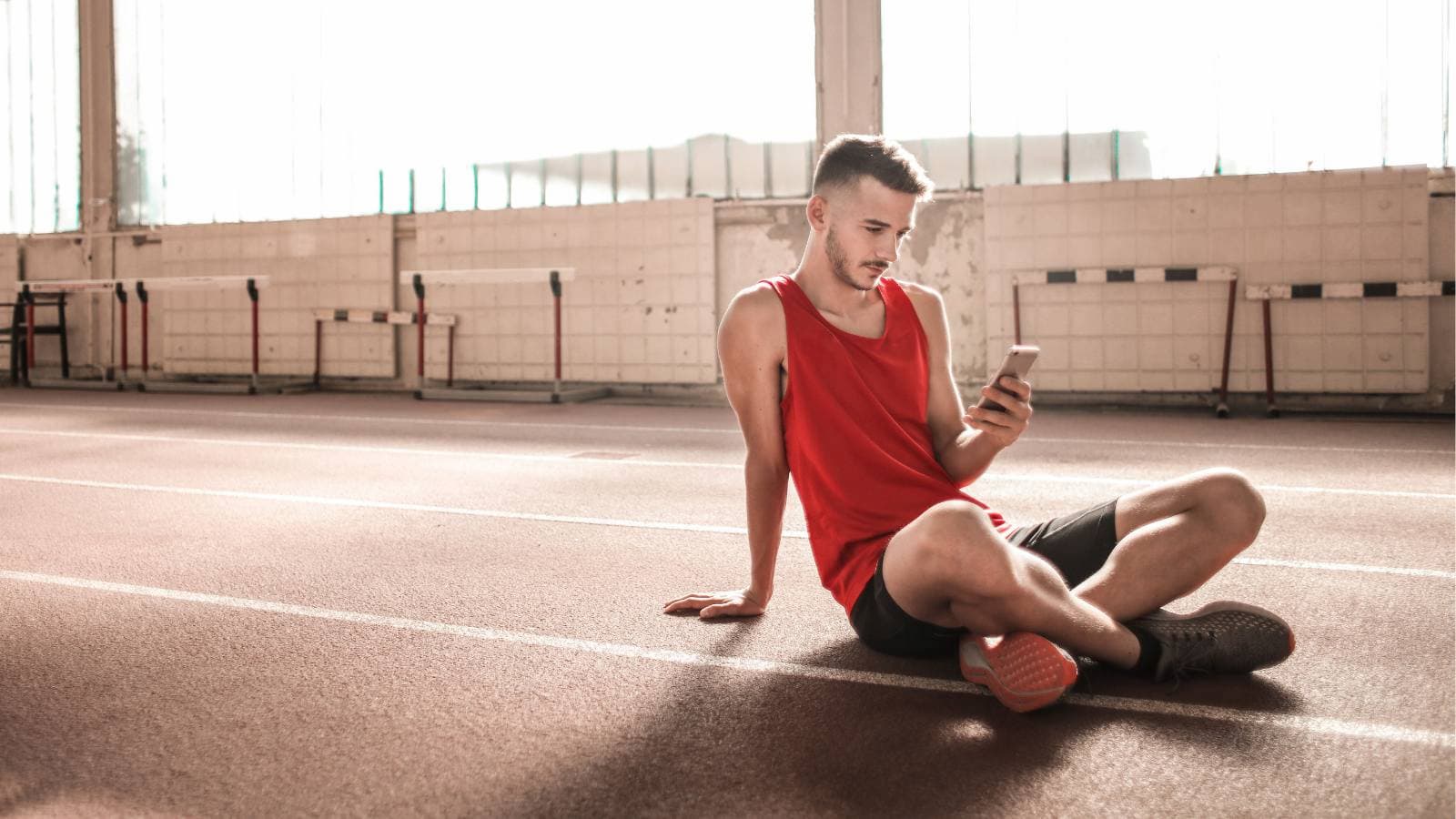 fatigued triathlete looking at digital devices instead of prioritizing recovery and rest