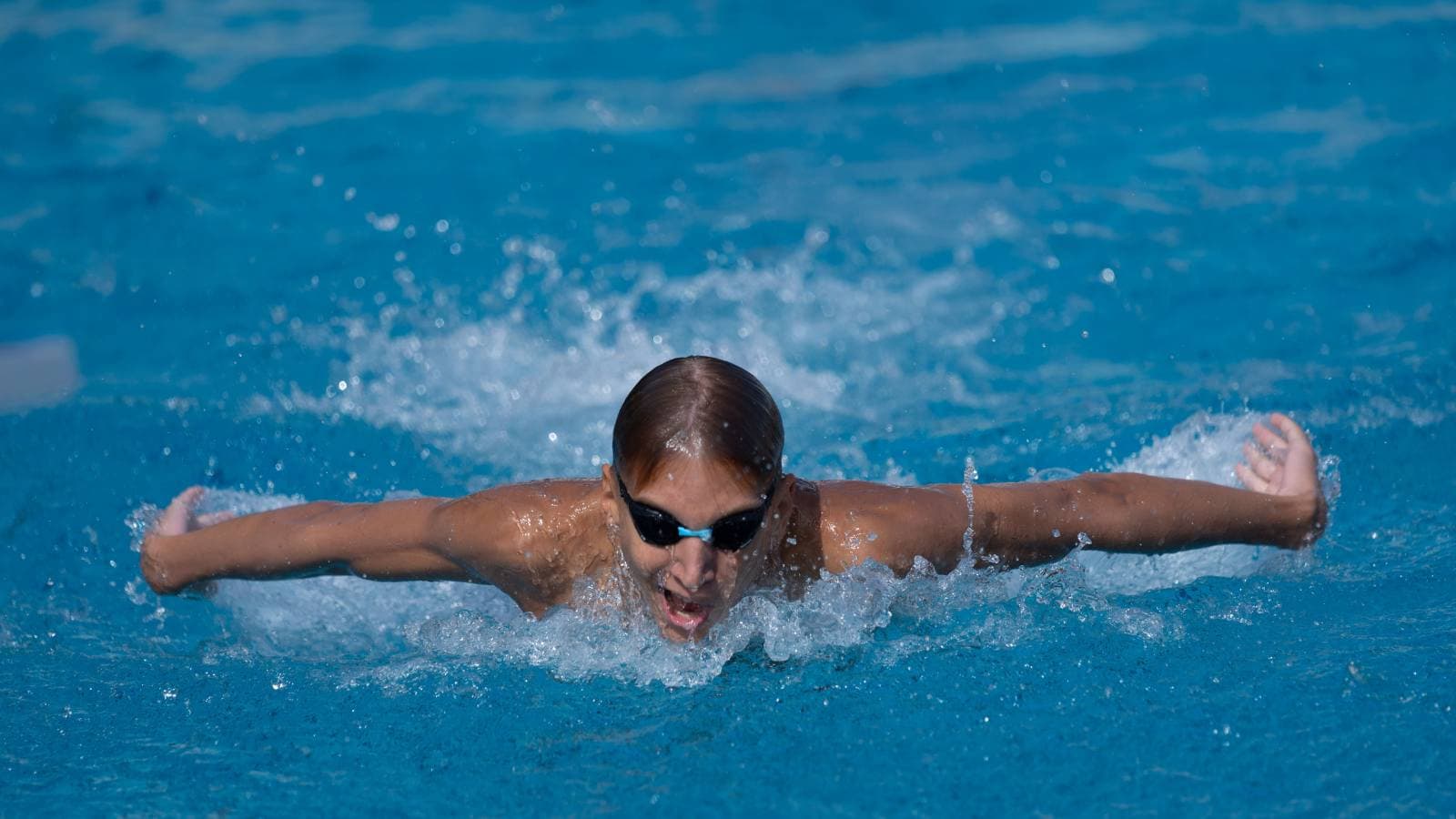 triathlete swimming freestyle with level body position to improve efficiency and reduce water resistance