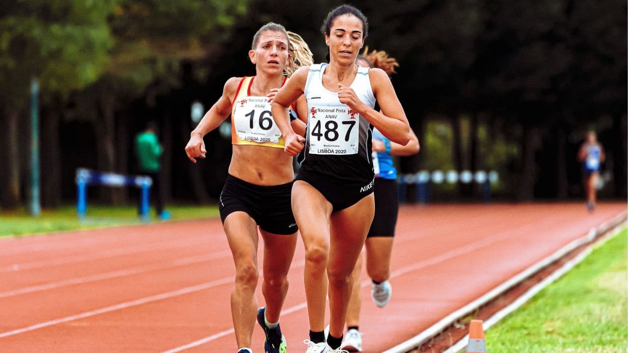 Female triathlete running during an endurance training session while managing performance throughout different phases of the menstrual cycle.