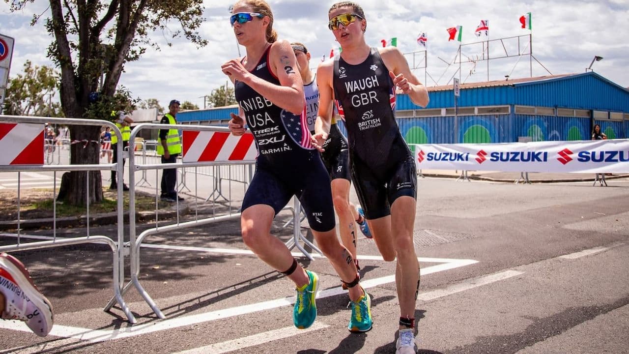 Close-up of a triathlete's arm swing showing elbows bent at approximately 90 degrees during an efficient running stride.
