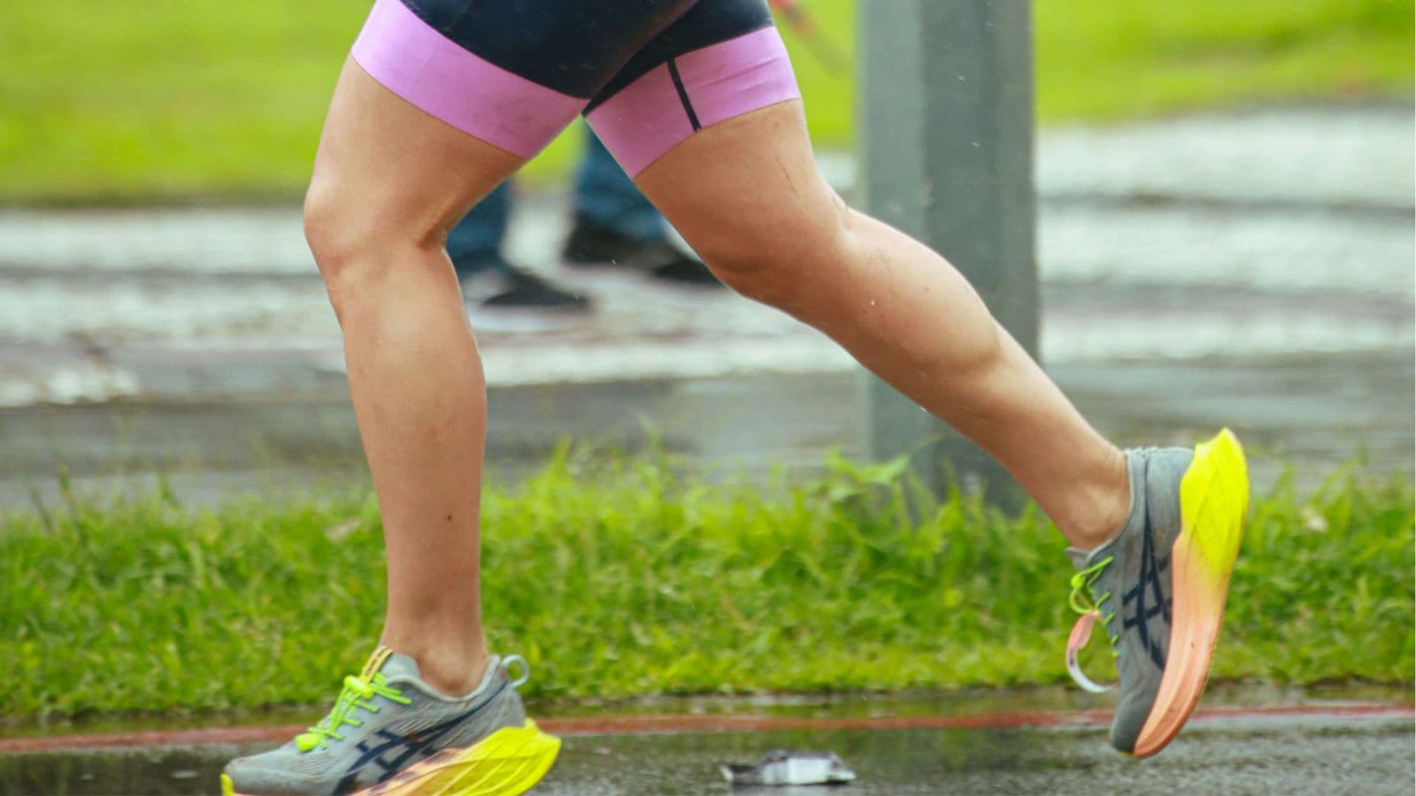 Runner demonstrating proper posture and arm swing technique while running on a track