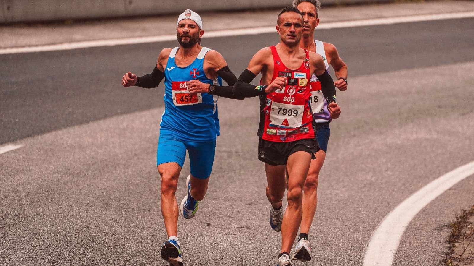 Triathlete crossing the finish line of an Ironman race while preparing to compete in a second Ironman later in the season.