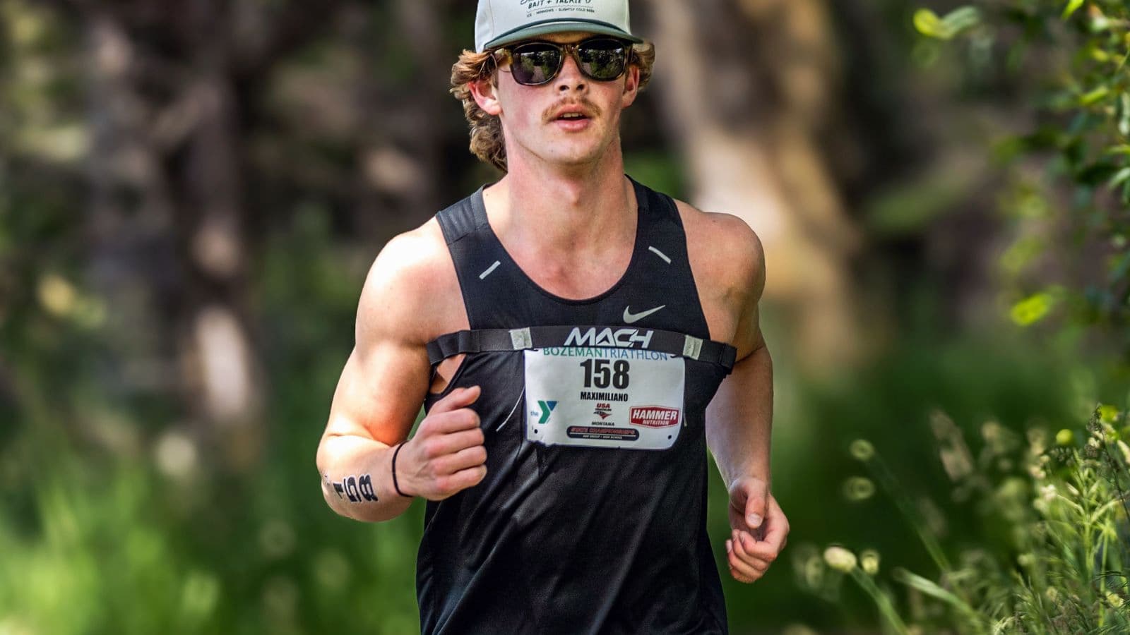 Runner maintaining a strong, steady pace during a tempo run on a paved road
