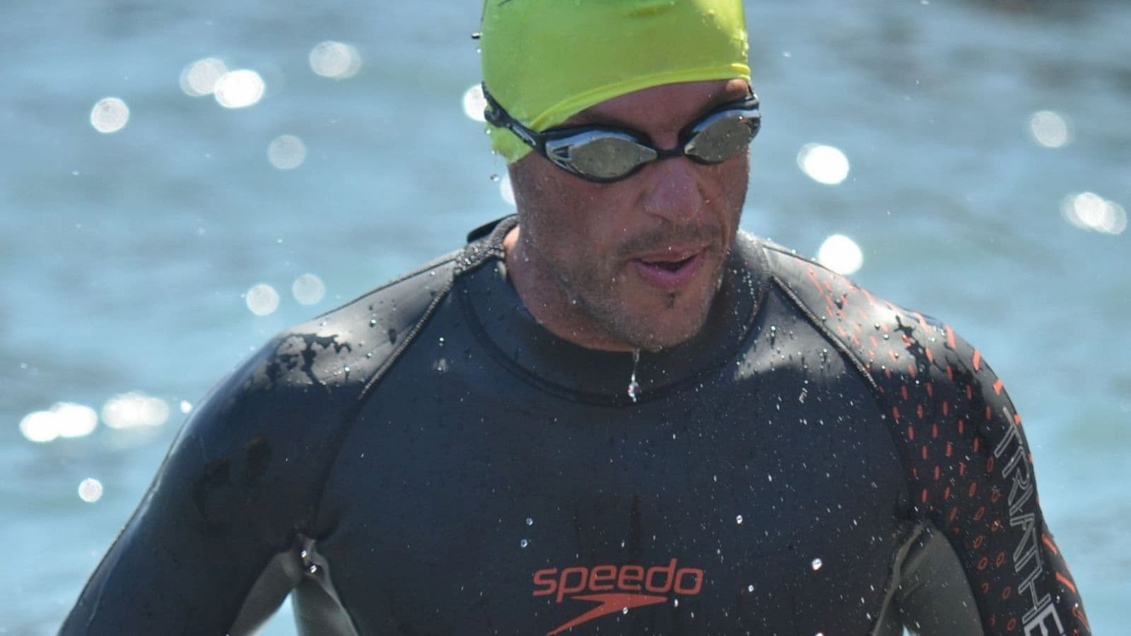 Triathlete practicing bilateral breathing while swimming freestyle in open water