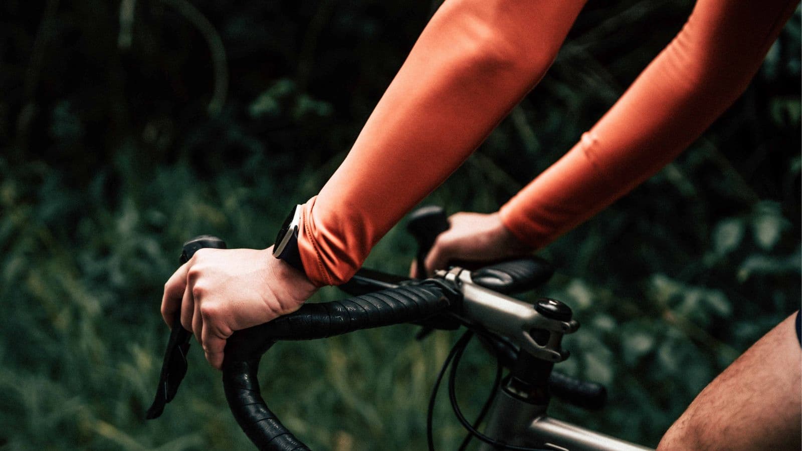 Cyclist adjusting saddle height and handlebar position during a bike fit to reduce hand numbness and saddle discomfort on long rides.