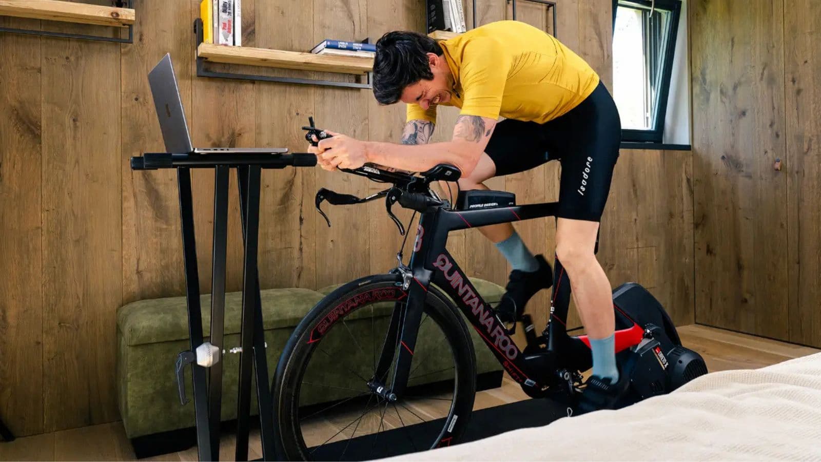 triathlete completing indoor cycling session while following virtual training program on smart trainer