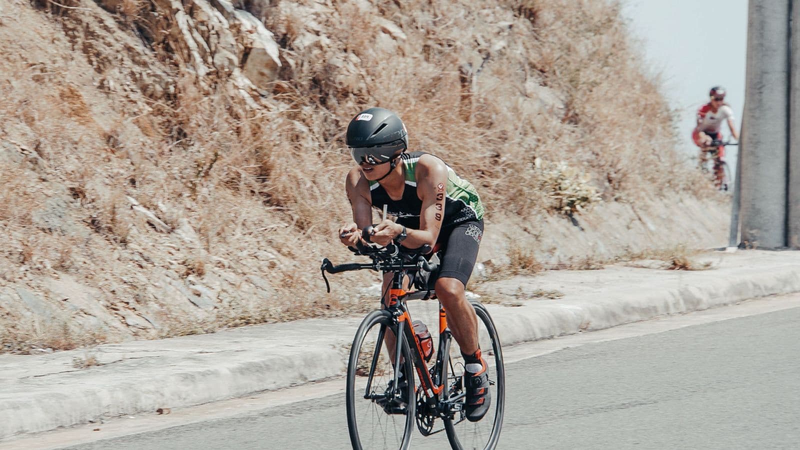 Cyclist leaning slightly into a crosswind while maintaining control on an open road