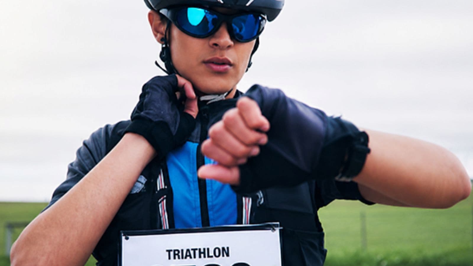 Triathlete wearing padded cycling gloves and bib shorts to reduce pressure on the hands and saddle during a long-distance ride.