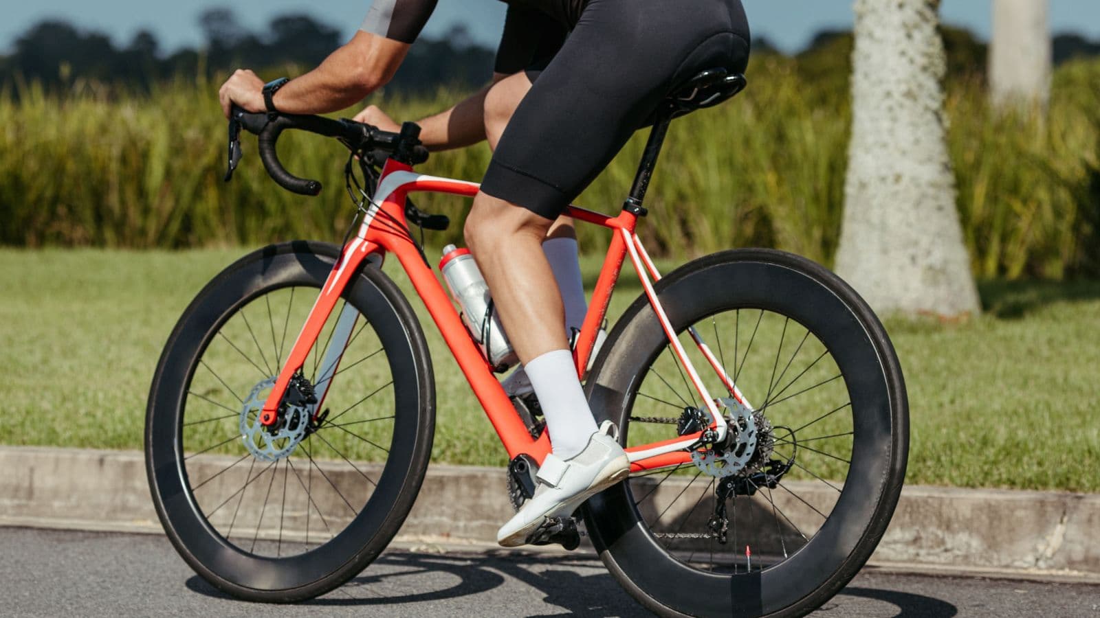 Cyclist adjusting saddle height and bike position during a professional bike fit to reduce knee pain on long rides.