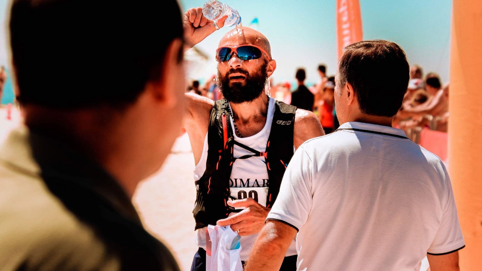 triathlete pouring water over head during hot triathlon race to stay cool and prevent overheating