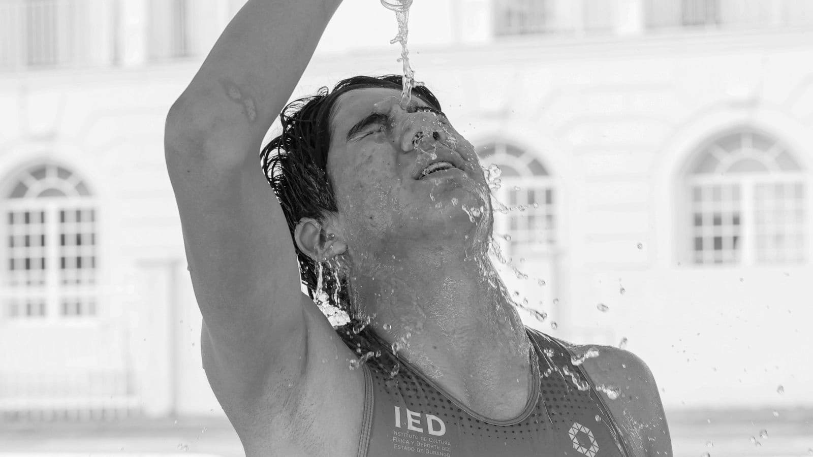 triathlete cycling in high temperatures while using hydration and cooling strategies during race