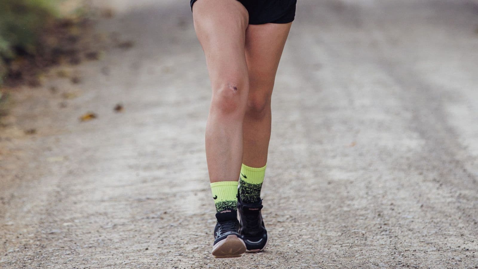 Triathlete running across rocky, uneven trail terrain to improve balance, coordination, and agility for triathlon performance.