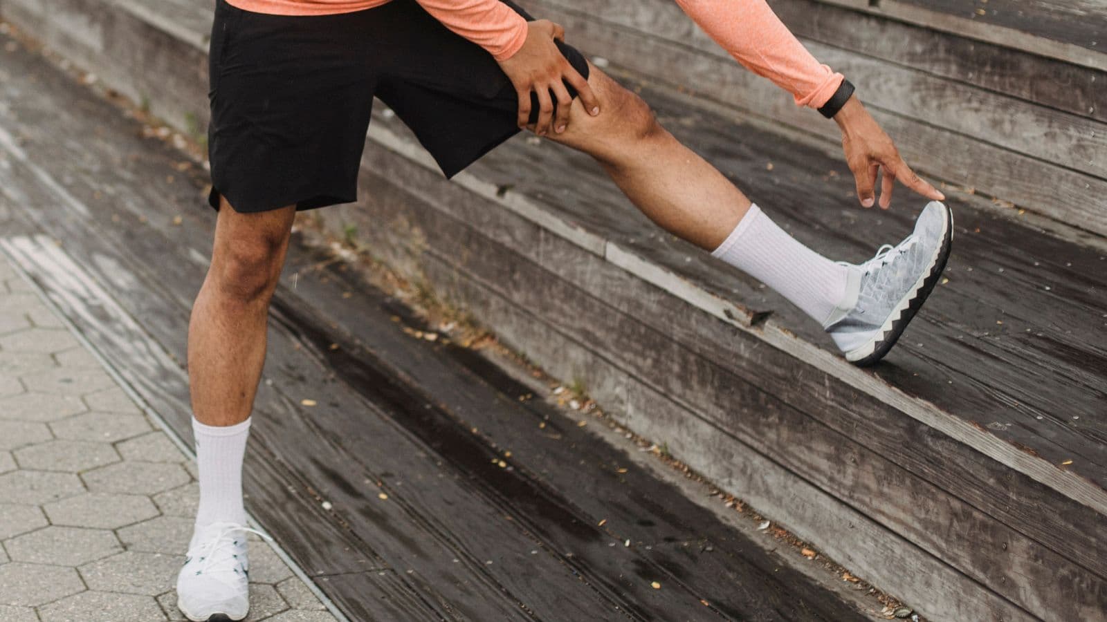 Runner gently stretching their hamstring after experiencing a mild strain during a training run.