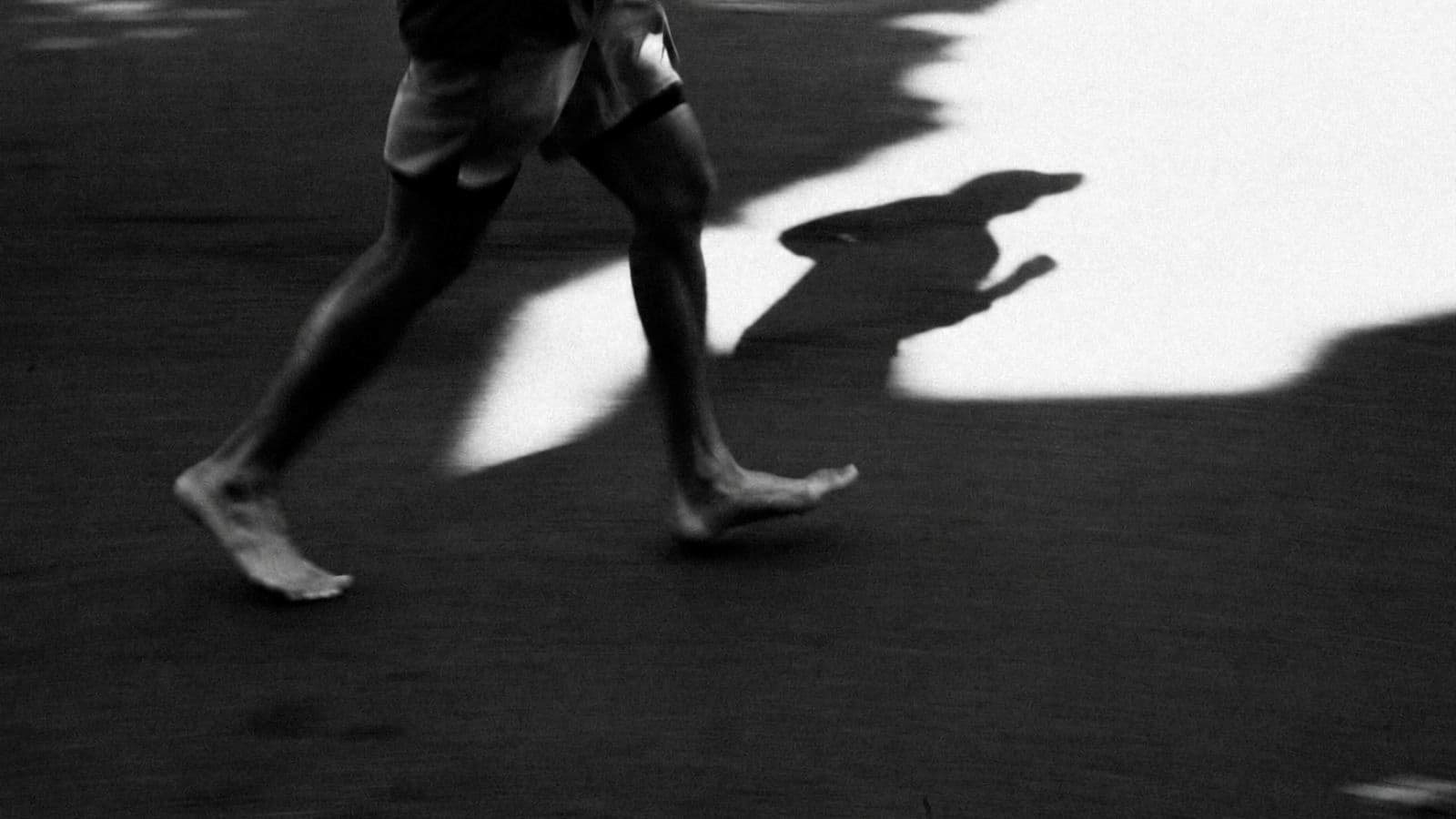 Triathlete performing barefoot foot and ankle strengthening exercises to improve stability and prepare for barefoot running.