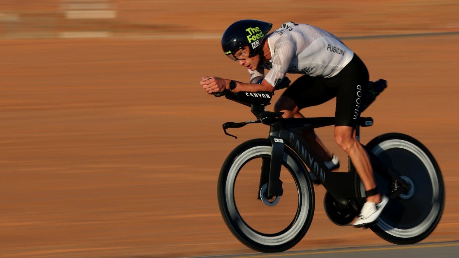 Triathlete looking through a downhill corner while maintaining a balanced position and controlled line during a race.