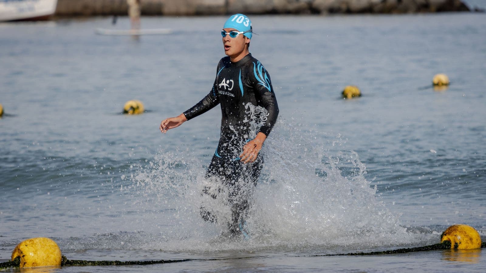 Triathlete swimming away from a turn buoy and sighting toward the next marker during an open water race.