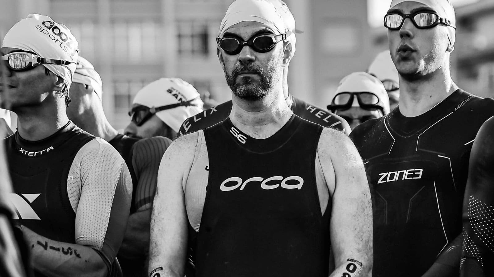 Triathlete walking steadily through the transition area after the swim to reduce dizziness before starting the bike leg.